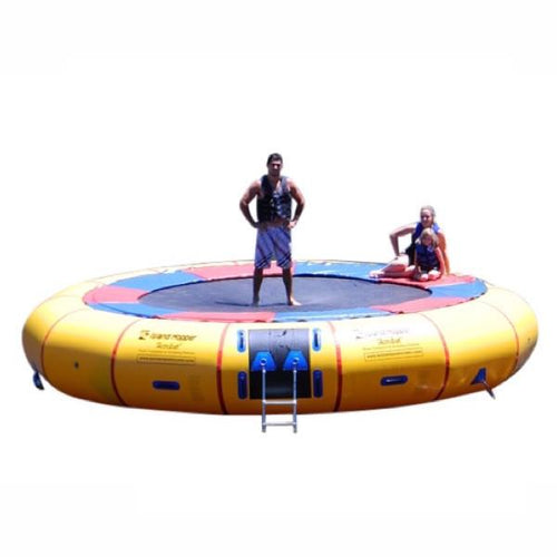 Island Hopper 20ft Acrobat Water Trampoline on a white background with 1 man standing on the black water trampoline surface and 1 girl sitting on the thin red and blue pad that is connected to the yellow inner tube. 