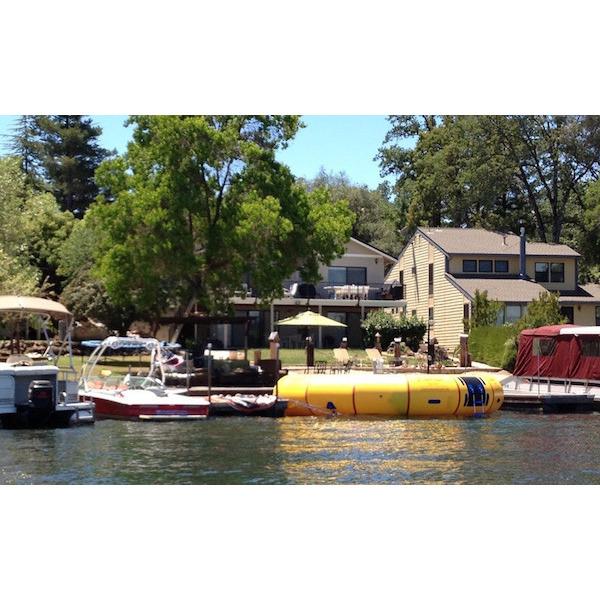 Yellow Island Hopper 20 Acrobat Water Trampoline on the lake next to shore in front of several lake houses. 