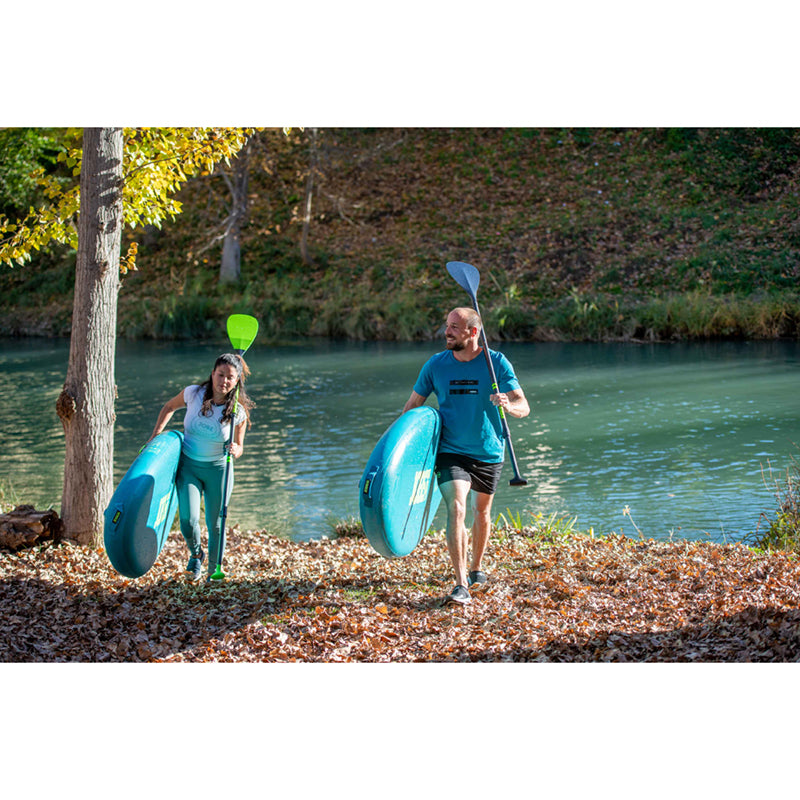 A man and woman each carrying Loa 11.6 Inflatable Paddle Boards away from the river.