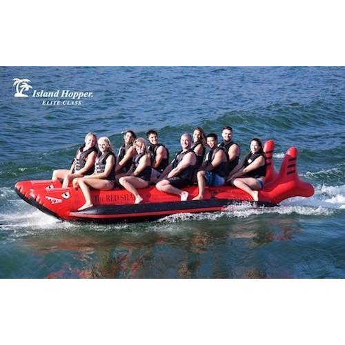 Island Hopper 10 Person Red Shark Banana Boat side view of the banana boat riding across the lake.